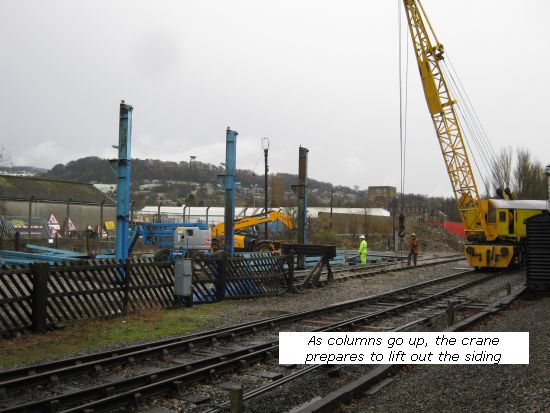 Shed steelwork - as the columns go up, crane prepares to lift a track panel
