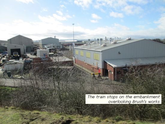 Train stops on embankment overlooking Brush
